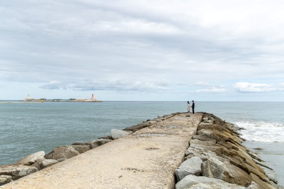 Narrow stone breakwater extending into the sea at Jumunjin